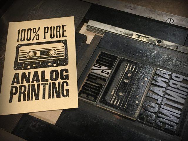 Letterpress print of linoblock cassette tape and wood type reading 100% Pure analog printing